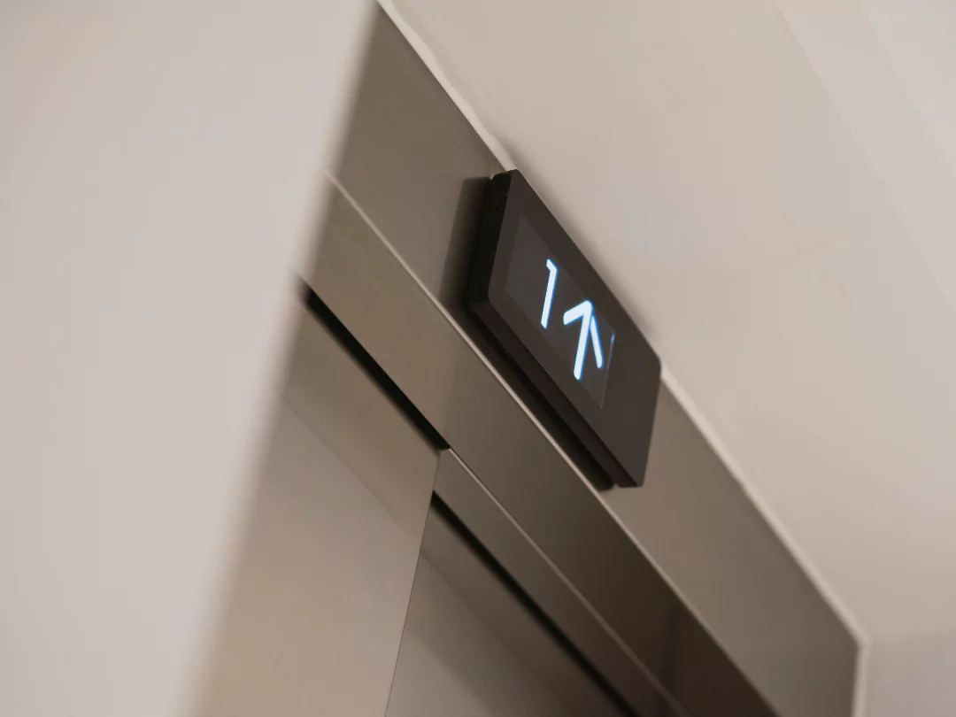 A close up of the apartment lift digital screen with arrows indicating going up a level.