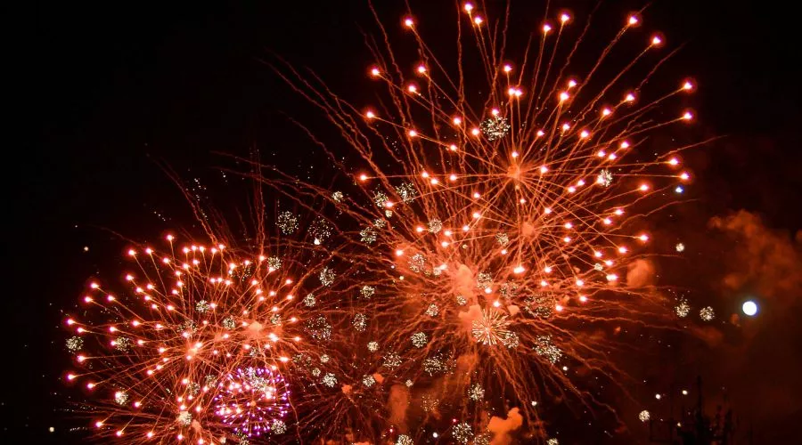 Orange fireworks bursting in a night sky.