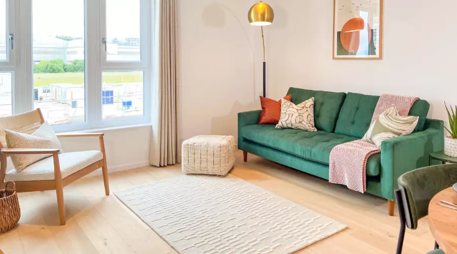 Open plan living room featuring a bold green sofa in an apartment at The Dials.