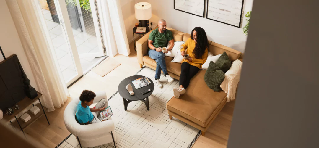 Family of mum, dad and young boy relaxing on a comfortable and modern sofa in their home at Brabazon, Bristol.