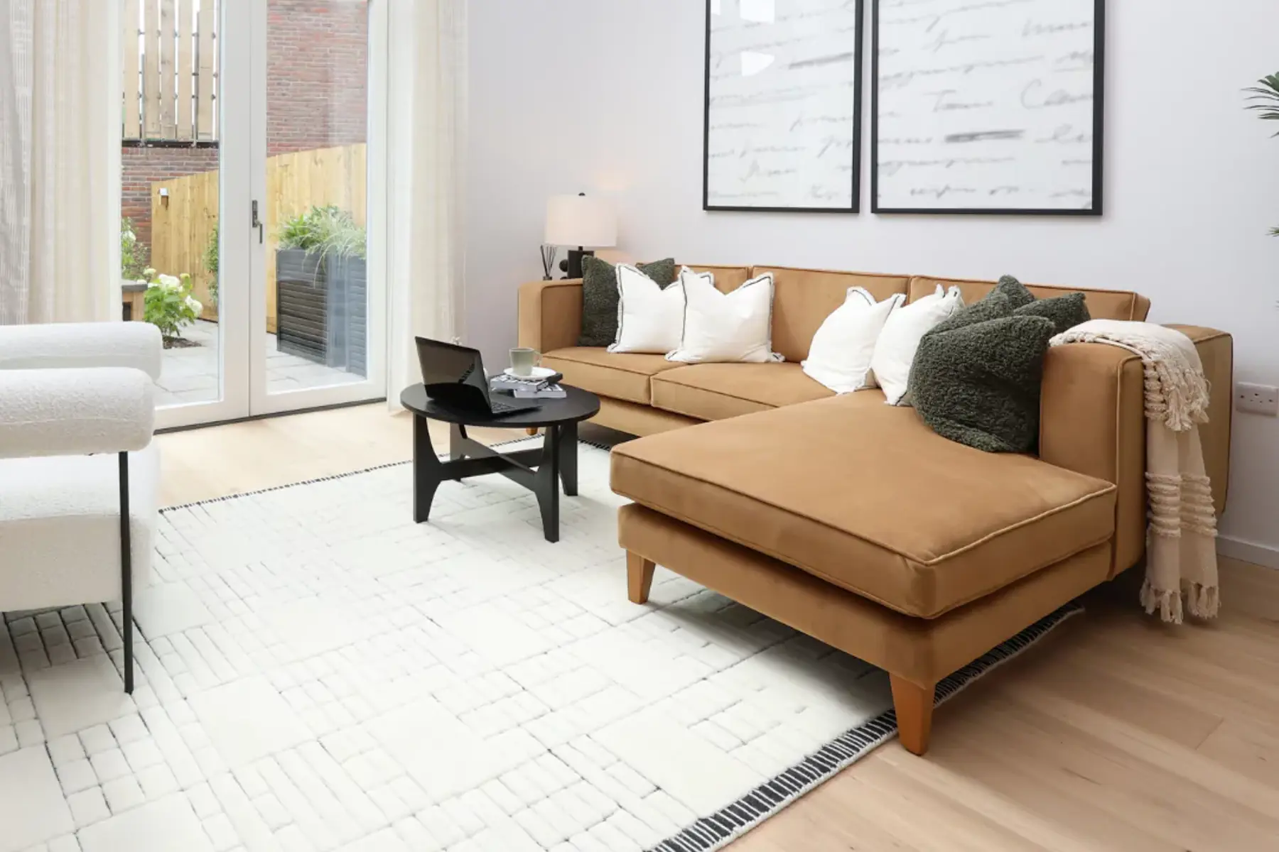 This living room is flooded with natural light featuring a beige corner sofa and cosy furnishings.